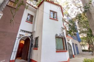 una casa blanca con una puerta roja en Nokal Exclusive Stay, en Ciudad de México