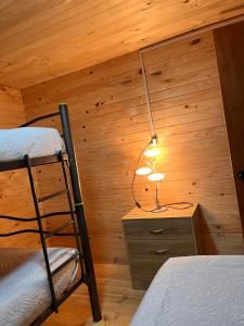 Un dormitorio con una cama y una lámpara en un escritorio. en Cabañas Maco, en Ranco