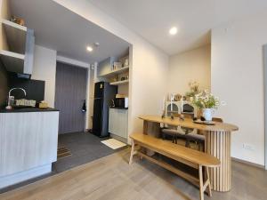 a kitchen and dining room with a table and bench at Relaxing 2 Bedroom in Khaoyai in Ban Huai Sok Noi