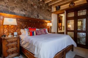a bedroom with a large bed with a wooden headboard at Sollano 34 in San Miguel de Allende
