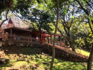 a house in the middle of a yard with trees at Chalé a beira de lago com churrasqueira em SP in Indaiatuba