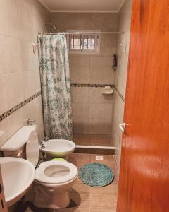 a bathroom with a toilet and a sink and a shower at Cabaña Clarita La Florida in La Florida