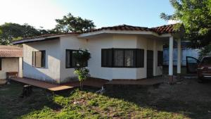 uma pequena casa branca com um carro estacionado em frente em Rose Marie Trujillo em Roboré