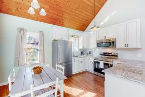 uma cozinha com armários brancos e um tecto de madeira em Lake Emory Gem em Franklin