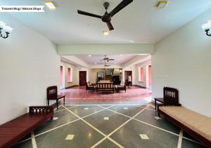a living room with benches and a ceiling fan at Pepper Corn Retreat by Travent Mug in Sakleshpur