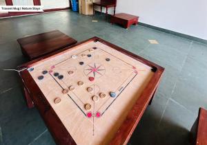 a large wooden table with a game of billiards at Pepper Corn Retreat by Travent Mug in Sakleshpur