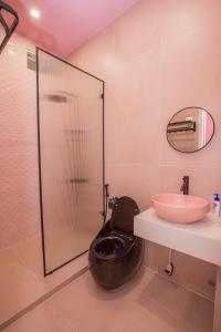 a bathroom with a shower with a toilet and a sink at Suri Homestay in Da Lat