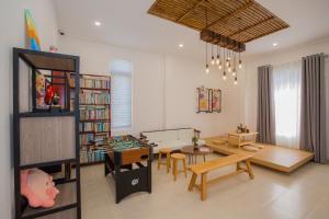 a living room with a table and a book shelf at Suri Homestay in Da Lat