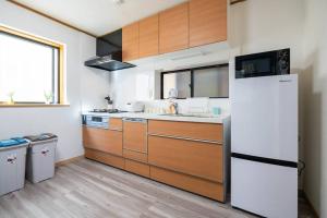 a kitchen with wooden cabinets and a white refrigerator at 匯家風花ビル in Tokyo