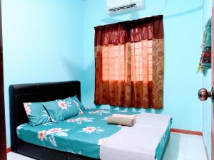 a bedroom with a bed and a window at ILHAM HOMESTAY Taman Sejati Mile 7 in Sandakan