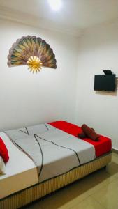 a bedroom with a bed with a decoration on the wall at Hotel Casa Reo in Kampong Bagan Lalang +4 photos
