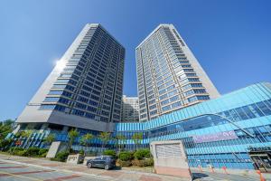 two tall buildings with a car parked in front of them at The Triny Urban Suites in Yongin