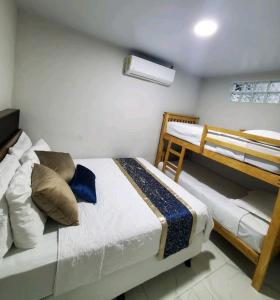 1 dormitorio con 2 camas y 1 litera en marhabibi home en Sonsonate