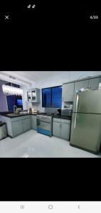 a large kitchen with a refrigerator and a stove at marhabibi home in Sonsonate