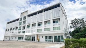 a white building with a sign on the top of it at โรงแรมบลอสซั่ม เพชรบูรณ์ Blossom Hotel in Phetchabun