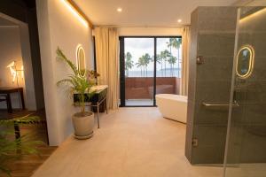 e bagno con doccia, vasca e servizi igienici. di Nacpan Beach Resort Managed by H Hospitality Group a El Nido