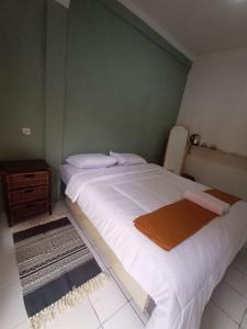 a bedroom with a large white bed and a table at Sea La Vie in Pangandaran
