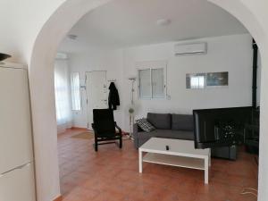 ein Wohnzimmer mit einem Sofa und einem TV in der Unterkunft Belvilla by OYO Casa de Aguila in Almogía