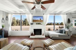 sala de estar con chimenea y ventilador de techo en Astroturism - 5 acres fenced - Pool & Jacuzzi - Pet friendly, en Twentynine Palms