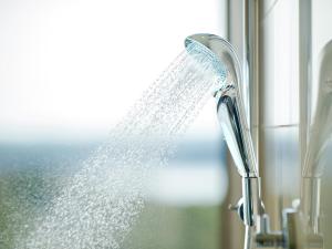 un cabezal de ducha con agua saliendo de él en Shima Kanko Hotel The Bay Suites, en Shima