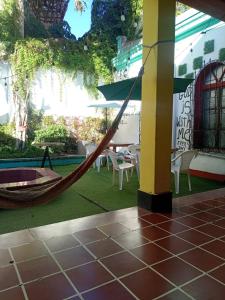 a hammock in a patio with a table and chairs at Karim Hostel in Guatemala
