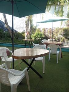 a group of tables and chairs with umbrellas at Karim Hostel in Guatemala