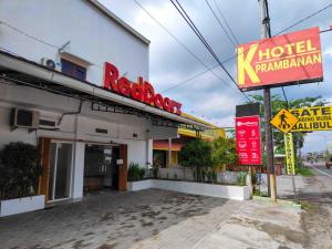 a hotel with a sign in front of a building at RedDoorz near Prambanan Temple in Klaten