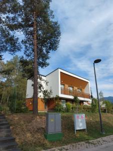 un edificio con un árbol delante de él en Tarcin Forest Resort Villa No 305, en Sarajevo