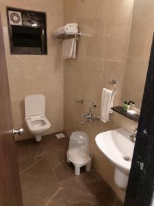 łazienka z toaletą i umywalką w obiekcie Chandanvan Club & Resort w mieście Jalālpur