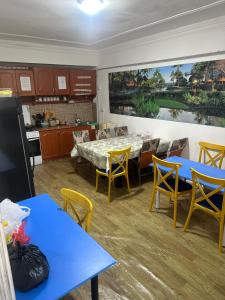 una cucina e una sala da pranzo con tavoli blu e sedie gialle di ДОМ Hostel a Almaty