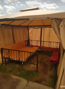 tenda con letto e tavolo sotto. di ДОМ Hostel a Almaty