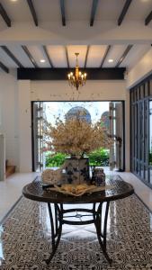a room with a table with a vase on it at Wynn Villa in Prachuap Khiri Khan