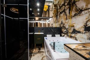 a bathroom with a bath tub and a sink at Złota Grota Centrum in Wrocław
