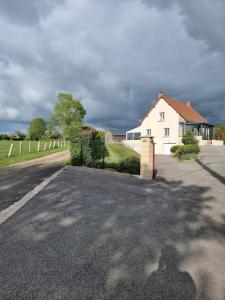 Eine Straße mit einem weißen Haus und einem Zaun in der Unterkunft Maison chaleureuse en Normandie in Habloville