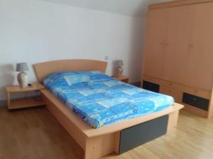 Una cama con un edredón azul encima. en Maison chaleureuse en Normandie en Habloville