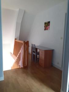 Zimmer mit einem Schreibtisch, einem Stuhl und einer Treppe in der Unterkunft Maison chaleureuse en Normandie in Habloville