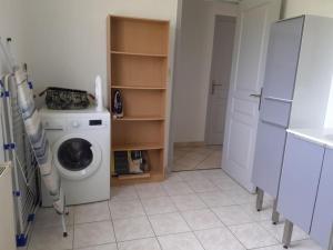 Wäschemöglichkeiten mit einer Waschmaschine und einem Kühlschrank in der Unterkunft Maison chaleureuse en Normandie in Habloville