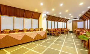 a banquet hall with tables and chairs and windows at Treebo Trend Swagatam Inn in Guwahati
