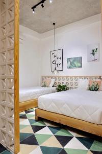2 letti in una camera da letto con pavimento a scacchi di URI HOUSE, 1-2 BR tourism apt, 5' walk Dragon Bridge a Da Nang
