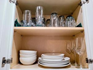 un armario lleno de platos y vasos en One room in a renovated duplex house near FSU, en Tallahassee