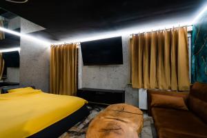 a bedroom with a yellow bed and a couch at Złota Grota Centrum in Wrocław