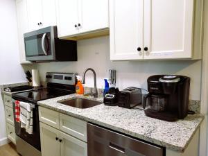 a kitchen counter with a sink and a microwave at One room in a renovated duplex house near FSU in Tallahassee +12 photos