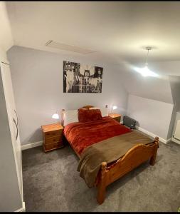 a bedroom with a bed with a red bedspread at Beanie’s North Swindon DoubleBed in Blunsdon Saint Andrew