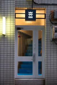 a entrance to a building with a sign above a door at Wharf Inn in Yokohama