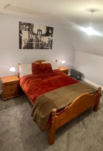 a bedroom with a large bed with a red comforter at Beanie’s North Swindon DoubleBed in Blunsdon Saint Andrew