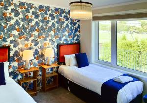 a bedroom with two beds and a wallpaper with fishes at Hobart Avenue Apartment The Residence in Sandy Bay