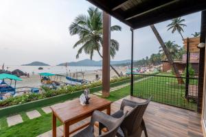 un patio con mesa y sillas y la playa en marron sea view resort, en Palolem