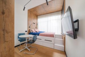 ein kleines Schlafzimmer mit einem Bett und einem Tisch in der Unterkunft Dzintaru studio in Jūrmala