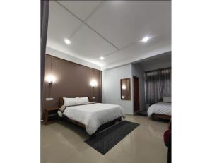 een slaapkamer met 2 bedden en witte lakens bij Hotel Dawa Tawang, Arunachal Pradesh in Tawang