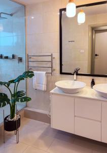 a bathroom with two sinks and a shower at Hobart Avenue Apartment The Residence in Sandy Bay